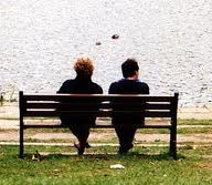 two people on bench by water